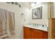 Bathroom featuring wood vanity, white countertop, and decorative mirror at 2982 S Atlantic Ave, New Smyrna Beach, FL 32169