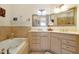 Neutral bathroom boasts double sinks, vanity, jacuzzi bathtub, and tile flooring at 2982 S Atlantic Ave, New Smyrna Beach, FL 32169