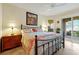 Comfortable bedroom boasts an iron bed frame, flamingo bedding, and sunlit windows at 2982 S Atlantic Ave, New Smyrna Beach, FL 32169