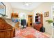 Bright home office with a window, antique desk, coral colored rug and built in bookcase at 2982 S Atlantic Ave, New Smyrna Beach, FL 32169