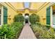 Inviting walkway through lush landscaping to building entrance with beautiful archway and red tile roof at 2982 S Atlantic Ave, New Smyrna Beach, FL 32169