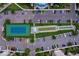 Aerial view of community tennis court, bocce court, parking, and building at 3 Riverwalk Dr # 404, New Smyrna Beach, FL 32169