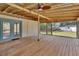 Spacious screened-in back porch with wood flooring, fan, and backyard view at 310 Main St, Enterprise, FL 32725