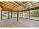 Large screened-in porch featuring wood floors and view of backyard and sheds at 310 Main St, Enterprise, FL 32725