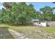 Expansive backyard featuring a storage shed, privacy fence, mature trees, and a stepping stone pathway at 310 Main St, Enterprise, FL 32725