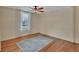 Bright bedroom featuring hardwood floors, a ceiling fan, and a window with curtains at 310 Main St, Enterprise, FL 32725