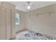 Bright bedroom featuring a ceiling fan, closet, window with blind, and decorative rug at 310 Main St, Enterprise, FL 32725