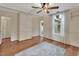 Spacious bedroom boasts wood floors, paneled walls, ceiling fan and natural light at 310 Main St, Enterprise, FL 32725