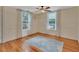 Bright bedroom with hardwood floors, windows with curtains, and a ceiling fan at 310 Main St, Enterprise, FL 32725