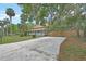 Charming two-story home with a welcoming front porch and a spacious driveway surrounded by lush greenery and mature trees at 310 Main St, Enterprise, FL 32725