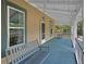 Charming covered front porch featuring wood floors, swing, and view of front yard at 310 Main St, Enterprise, FL 32725