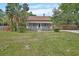 Inviting two-story home with a classic front porch, green lawn, and tropical palm trees enhancing its curb appeal at 310 Main St, Enterprise, FL 32725