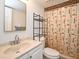 Practical bathroom with a vanity, mirror, toilet, and shower with a patterned curtain at 3131 S Ridgewood Ave # 4120, Daytona Beach, FL 32119