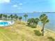 Beautiful pool with stunning waterfront views and lush landscaping featuring palm trees on a sunny day at 3131 S Ridgewood Ave # 4120, Daytona Beach, FL 32119