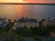 Aerial view of waterfront home with screened pool and private dock at sunset at 3310 John Anderson Dr, Ormond Beach, FL 32176