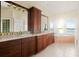 Bright bathroom boasts dual sinks, dark wood cabinetry, and a large soaking tub overlooking the serene waterfront at 3310 John Anderson Dr, Ormond Beach, FL 32176