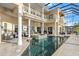 Enclosed pool area with spa, seating, second story balcony, and clear blue sky and tile flooring at 3310 John Anderson Dr, Ormond Beach, FL 32176