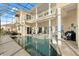 Enclosed pool area with spa, ceiling fans, seating, and a second story balcony with view at 3310 John Anderson Dr, Ormond Beach, FL 32176