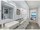 Bathroom with dual sinks, granite counters, and a view into the bedroom with ocean scenery at 3425 S Atlantic Ave # 1206, Daytona Beach Shores, FL 32118