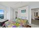 Inviting bedroom featuring a vibrant quilt, adjacent bathroom, and seamless transition to other living spaces at 3425 S Atlantic Ave # 1206, Daytona Beach Shores, FL 32118