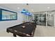 Upscale game room featuring a billiards table under stylish lighting, with an exercise room viewed through glass doors at 3425 S Atlantic Ave # 1206, Daytona Beach Shores, FL 32118