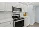 Kitchen features a stainless steel oven, microwave, marble backsplash, and white cabinets at 3425 S Atlantic Ave # 1206, Daytona Beach Shores, FL 32118