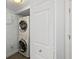 Convenient laundry area featuring stacked washer and dryer and white door at 3425 S Atlantic Ave # 1206, Daytona Beach Shores, FL 32118
