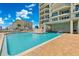 Sparkling community pool with a brick deck and lounge chairs under a sunny sky at 3425 S Atlantic Ave # 1206, Daytona Beach Shores, FL 32118