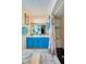 Bright bathroom with a shower, light tile, and turquoise cabinets with a dual sink at 3441 Country Walk Dr, Port Orange, FL 32129
