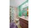 Colorful bathroom with a shower/tub, green walls, purple vanity and ample lighting at 3441 Country Walk Dr, Port Orange, FL 32129