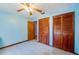 Light blue bedroom with a ceiling fan, tile floor and wood-paneled closets at 3441 Country Walk Dr, Port Orange, FL 32129