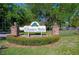 Community sign for 'Country Walk', with brick columns, landscaping, and trees in the background at 3441 Country Walk Dr, Port Orange, FL 32129