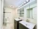 Modern bathroom with double vanities, stylish lighting, and a tiled shower at 370 S Center St, Ormond Beach, FL 32174