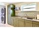 Well-lit kitchen with modern green cabinets, tiled backsplash, stainless steel appliances, and a window at 370 S Center St, Ormond Beach, FL 32174