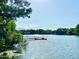 Picturesque lake view with a private dock, bordered by lush trees and greenery at 370 S Center St, Ormond Beach, FL 32174