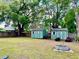Large backyard featuring two storage sheds and green space with mature landscaping at 370 S Center St, Ormond Beach, FL 32174