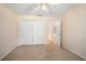 Bedroom featuring light walls and carpet with a closet and entry door at 405 Secluded Oaks Trl, Deland, FL 32724
