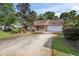 Attractive single-story home with a brick facade, attached garage, and a long driveway at 405 Secluded Oaks Trl, Deland, FL 32724