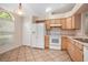 Well-lit kitchen featuring tile floors, a white refrigerator, and matching appliances at 405 Secluded Oaks Trl, Deland, FL 32724
