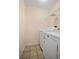 Functional laundry room showcasing a washing machine, dryer, tile floors, and wire shelving at 405 Secluded Oaks Trl, Deland, FL 32724