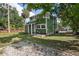 View of the side and front of the two-story home with green siding, white trim, and a well-manicured lawn at 415 W Church St, Deland, FL 32720