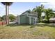 Green two-story home with white trim surrounded by a well-maintained lawn and landscaping on a sunny day at 415 W Church St, Deland, FL 32720