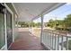 Spacious front porch with wood flooring offers a relaxing outdoor space with views of the neighborhood at 415 W Church St, Deland, FL 32720