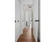 Hallway featuring wood-look floors and multiple doors to other rooms, creating a sense of connectivity at 415 W Church St, Deland, FL 32720