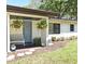Close-up of a charming front porch with a blue door, hanging plants, and a cozy bench at 421 Hope Ter, Maitland, FL 32751