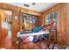 Wood paneled bedroom with windows and closet, featuring a table covered in a variety of items at 4293 Cypress Bnd, Geneva, FL 32732