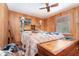 Wood paneled bedroom with ceiling fan, two windows, and a bed, appearing cluttered at 4293 Cypress Bnd, Geneva, FL 32732