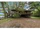 Unique home exterior featuring elevated deck and a covered area underneath, surrounded by lush trees at 4293 Cypress Bnd, Geneva, FL 32732