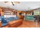 Comfortable living room open to the kitchen featuring rustic wood walls and a cozy blue couch at 4293 Cypress Bnd, Geneva, FL 32732