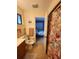Bathroom with a floral shower curtain, tile flooring, and access to bedroom at 4401 Sea Mist Dr # 201, New Smyrna Beach, FL 32169